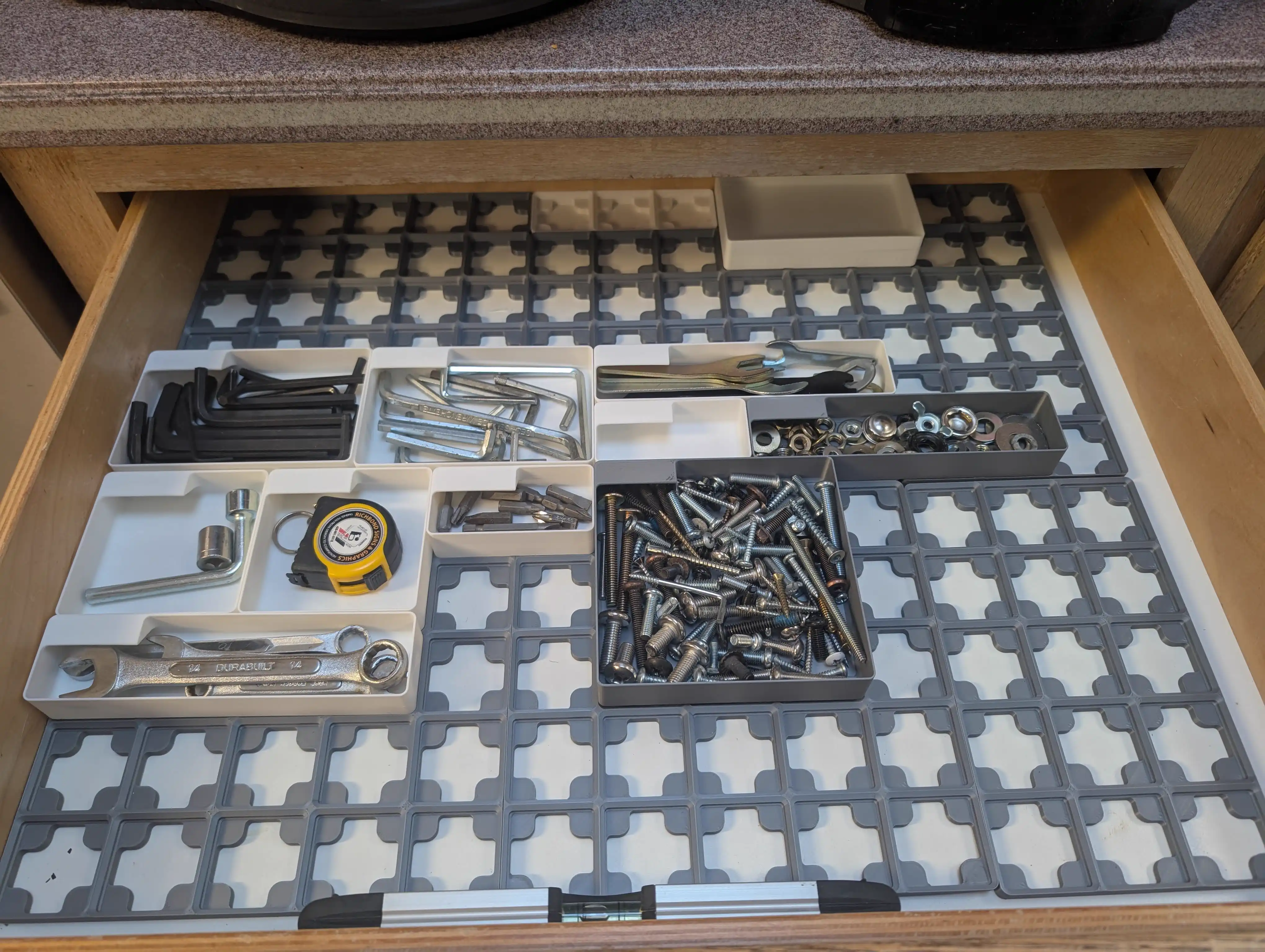 Several printed Gridfinity bins loaded with tools and parts