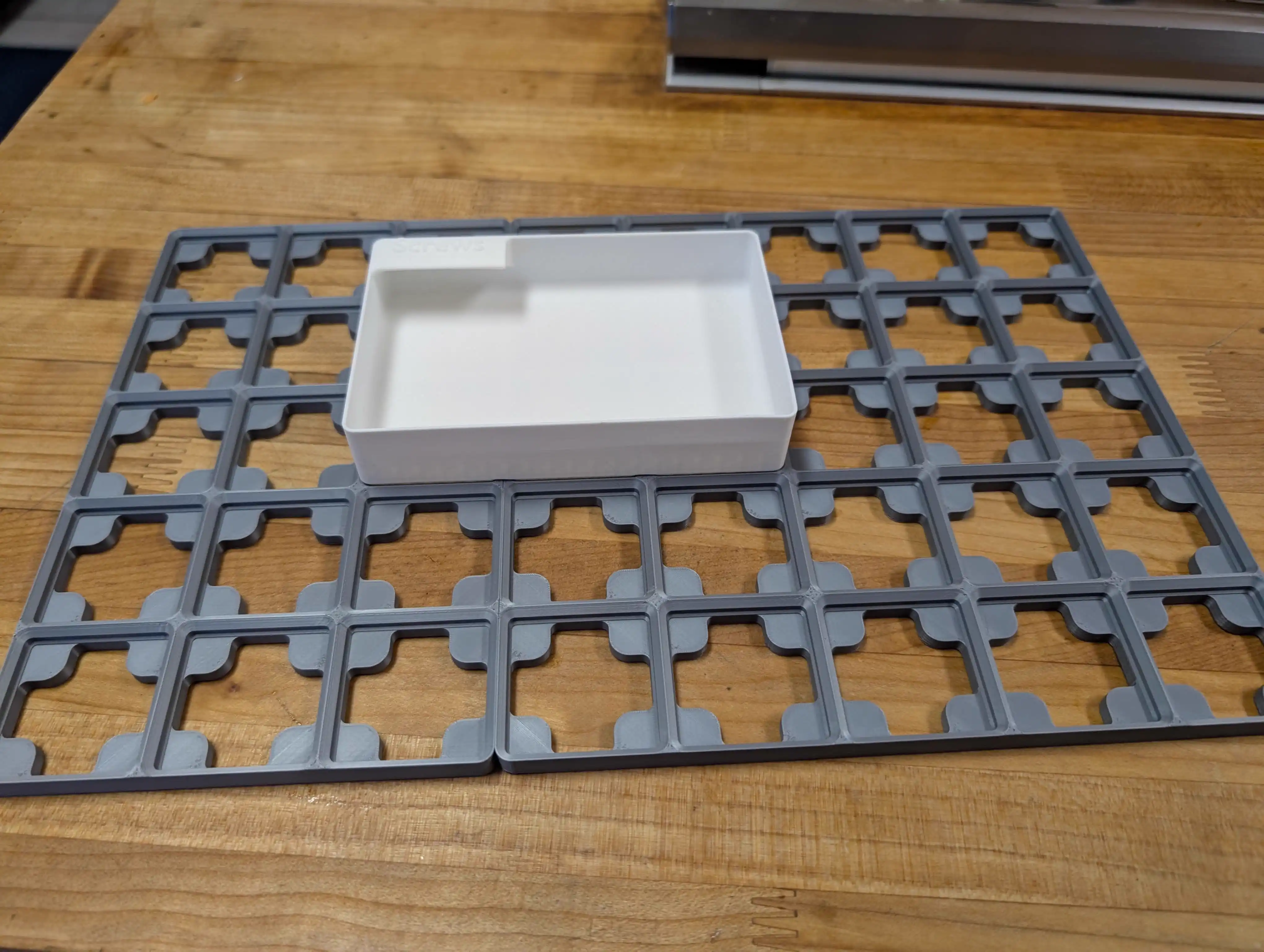 Test fitting a Gridfinity bin onto a baseplate