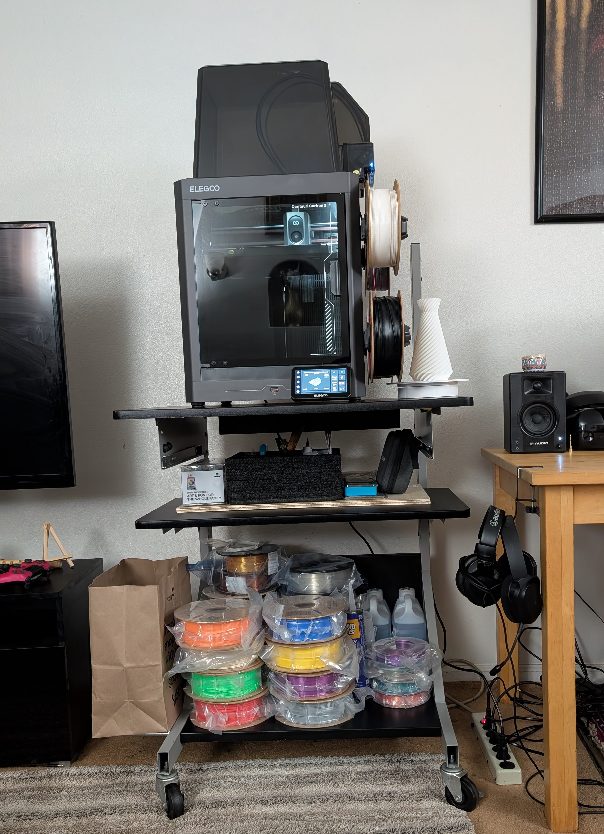 Elegoo Centauri Carbon 2 printer set up on an indoor rolling stand with supplies organized below