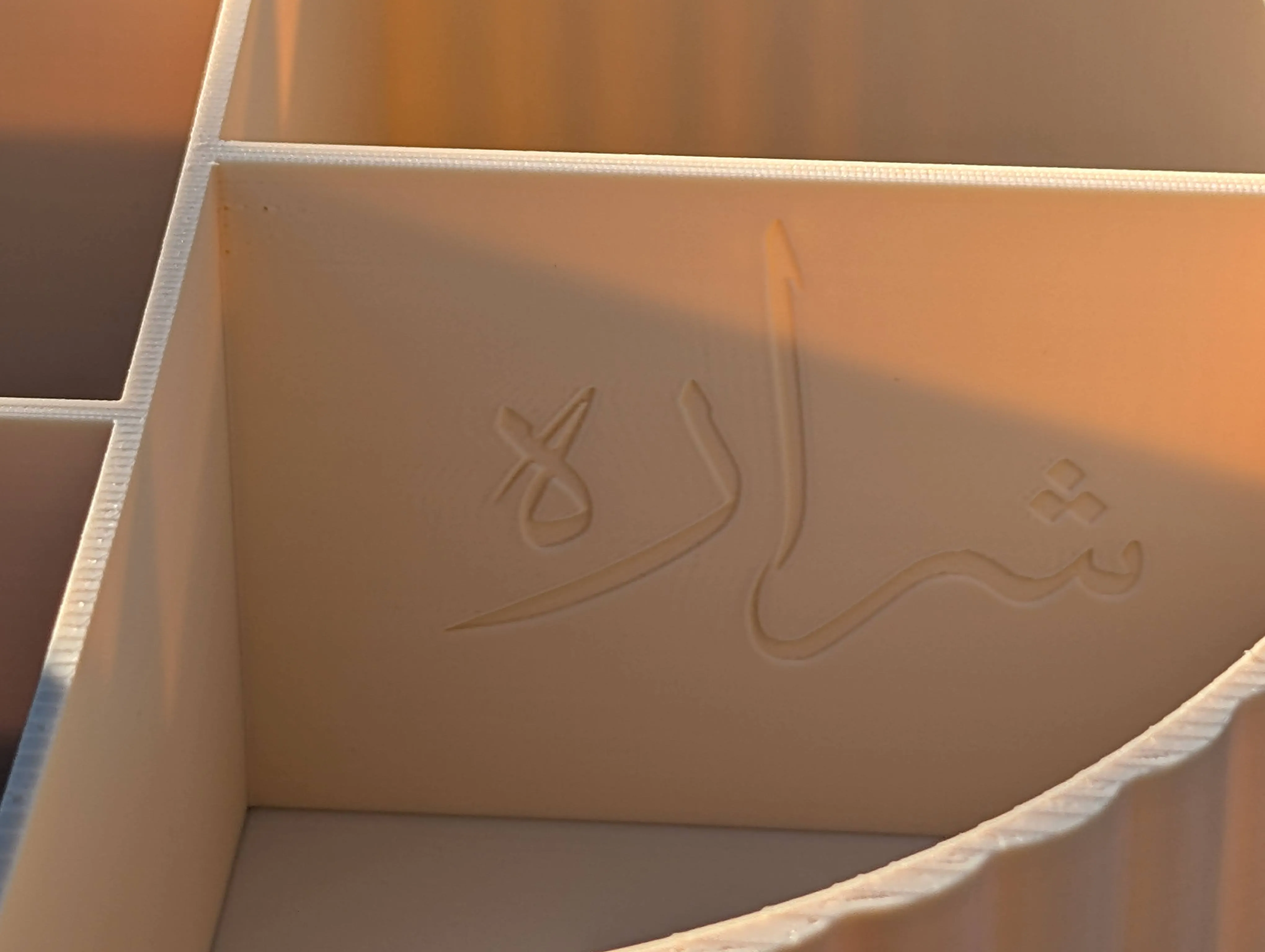 Close-up of the 3D-printed makeup organizer showing embossed Farsi name