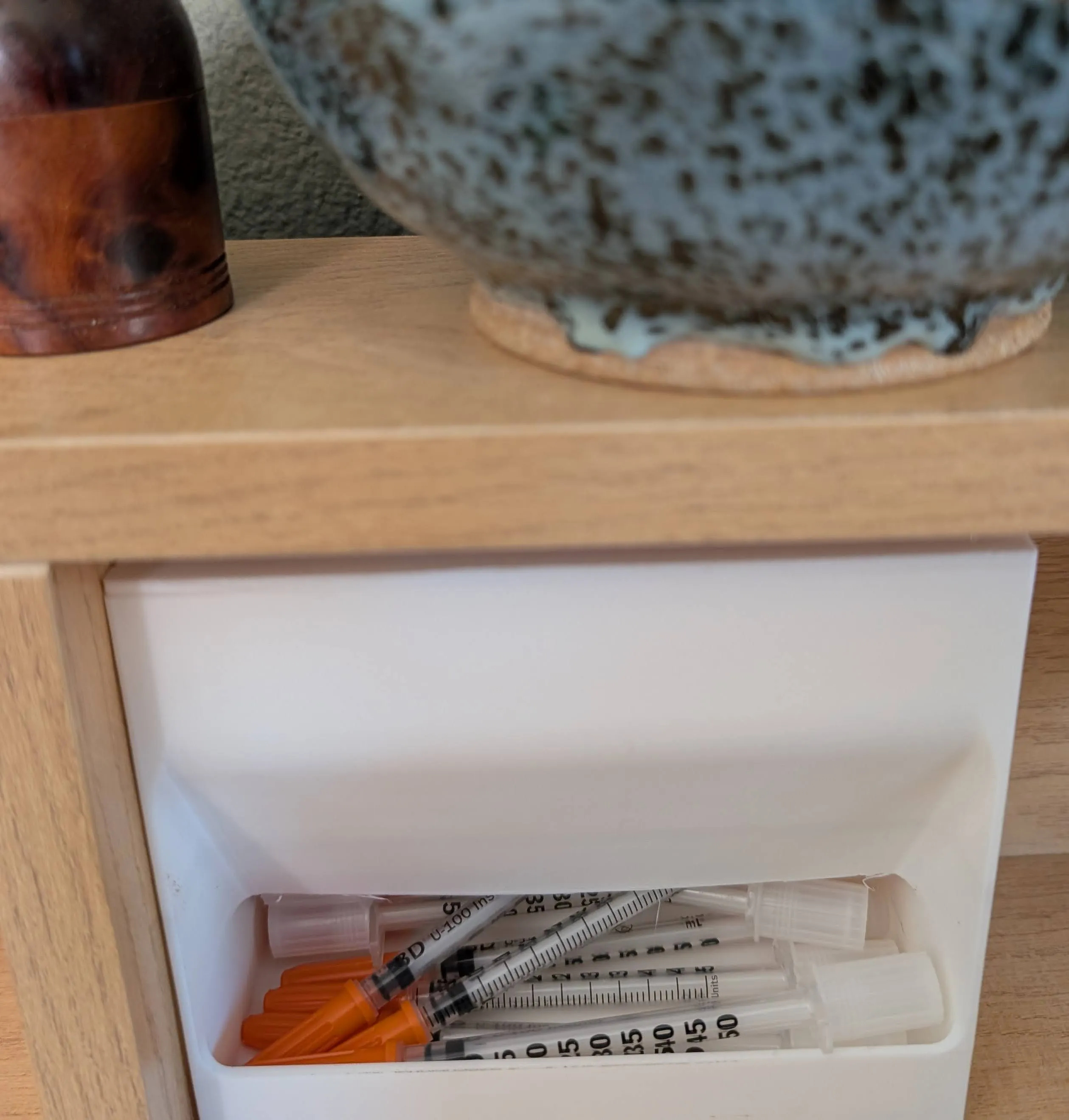 3D-printed insulin syringe dispenser mounted on a wall