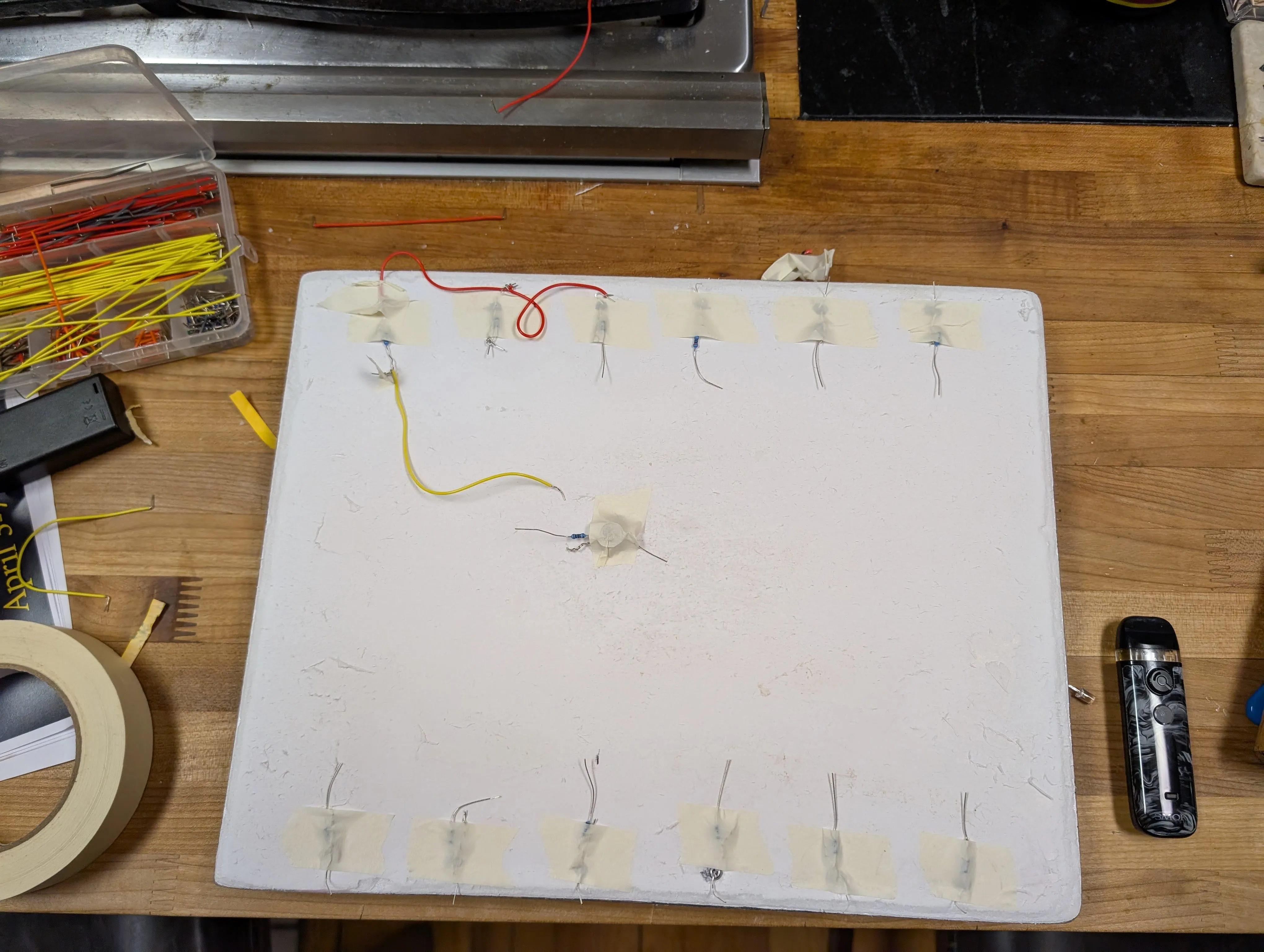 Back of the epoxy art piece showing drilled holes with LEDs and resistors installed