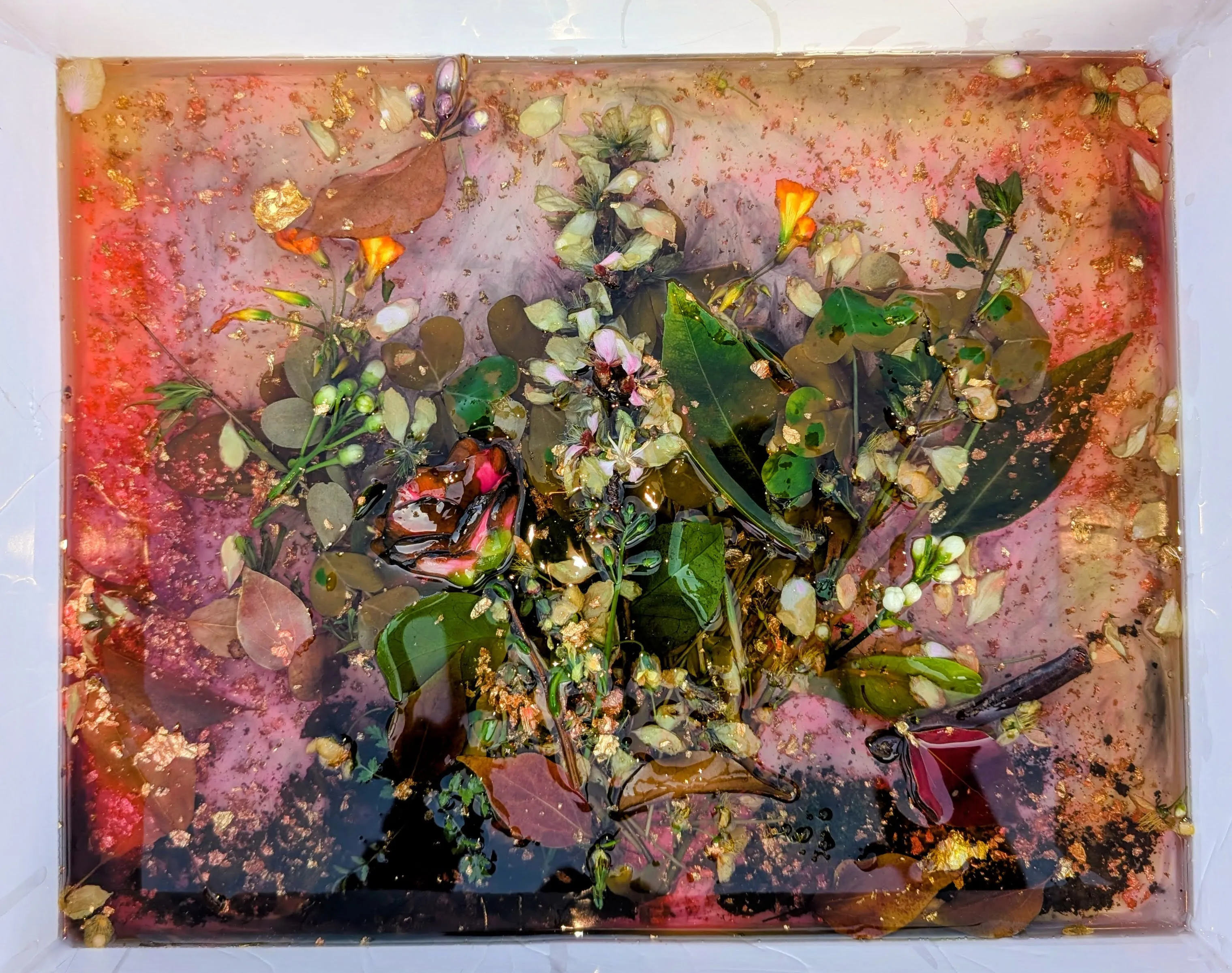 Additional clear and tinted epoxy layers building depth over the flowers