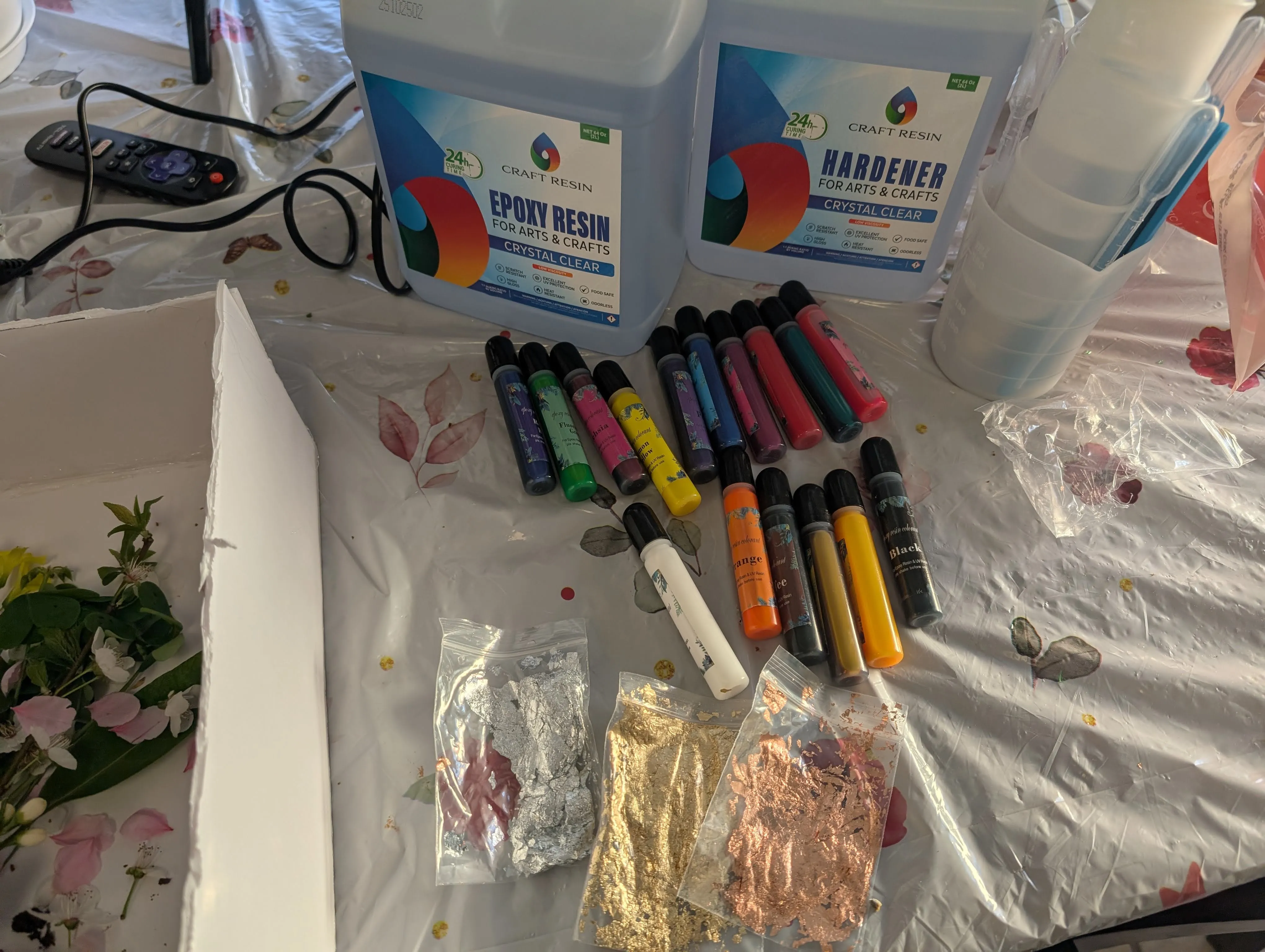 Epoxy resin supplies including colorant, gold flakes, mixing cups, and gloves